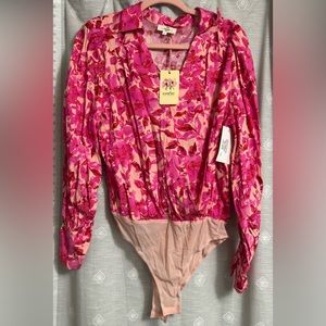 It includes a collared neckline, a v front, long sleeves, a light pink, 2 snap